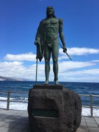 Rear view of statue against sea against sky