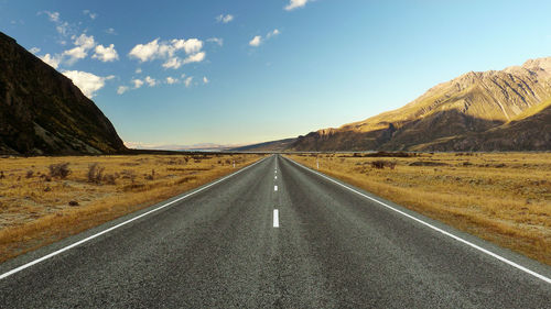 Country road on landscape against sky