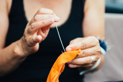 Midsection of woman sewing in workshop