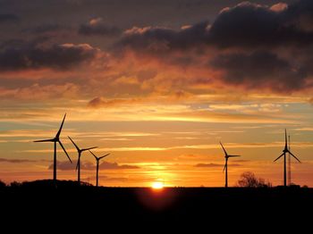 Silhouette of wind turbines at sunset