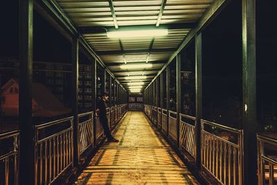 Man standing on illuminated footbridge