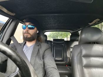 Man wearing sunglasses sitting in car