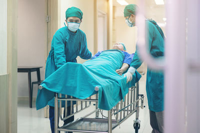 Doctor getting their patient ready for the next procedure in the corridor, a medical team is pushing