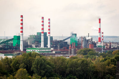 Panoramic view of factory and buildings against sky