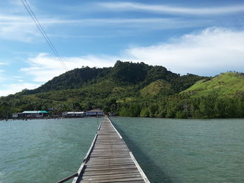 Scenic view of lake by mountains against sky