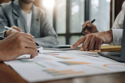 Midsection of business colleagues working on table