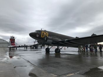 Airplane on runway against sky