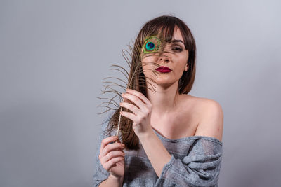 Portrait of beautiful woman wearing hat against gray background