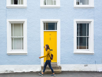 Full length of woman standing against building