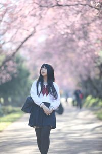 Woman standing on cherry blossom