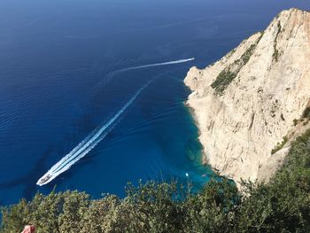 High angle view of trees by sea against blue sky