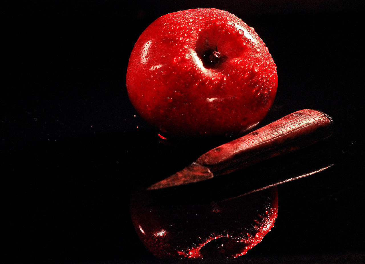 CLOSE-UP OF APPLE ON BLACK BACKGROUND