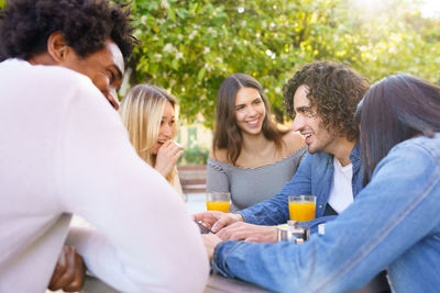 Friends sitting by table