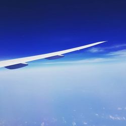 Cropped image of airplane flying over clouds