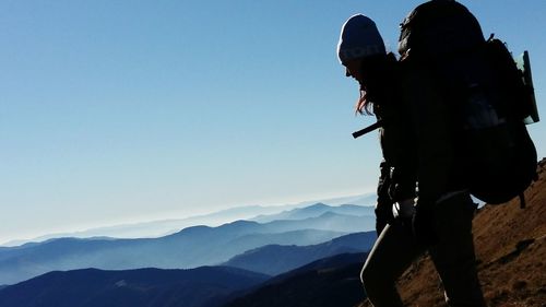 Man with arms outstretched on mountain during sunset