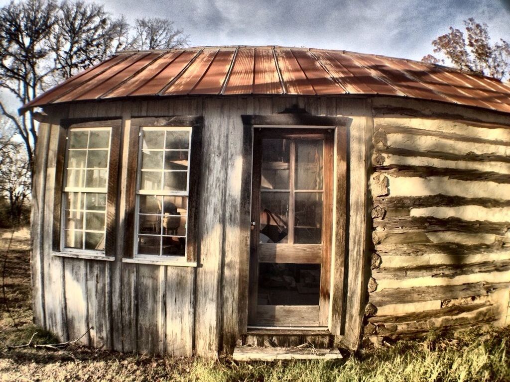 building exterior, architecture, built structure, window, house, wood - material, abandoned, old, sky, obsolete, door, residential structure, damaged, closed, day, run-down, weathered, tree, outdoors, grass