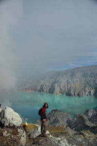 Man standing on rocks against mountain