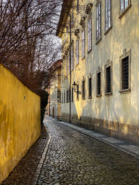 Empty footpath amidst buildings in city