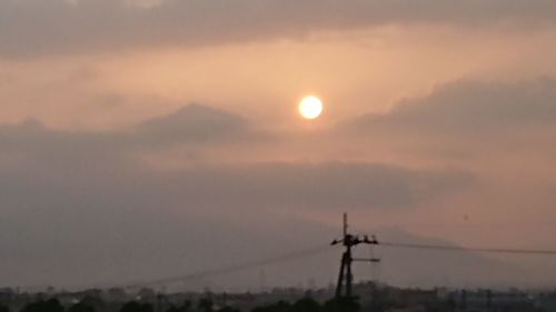 Silhouette windmill against sky during sunset