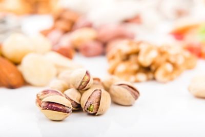 Close-up of fresh pistachios on white table