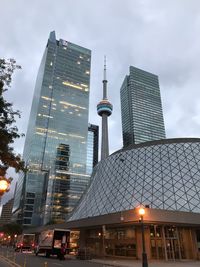 Low angle view of modern buildings against cloudy sky