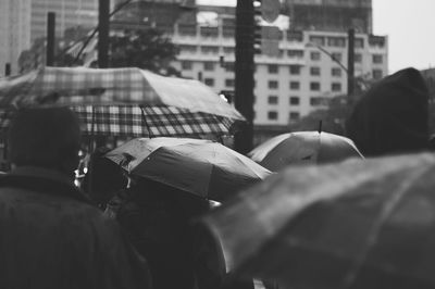People with umbrellas walking on street in rain