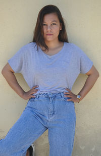 Portrait of beautiful woman standing against wall