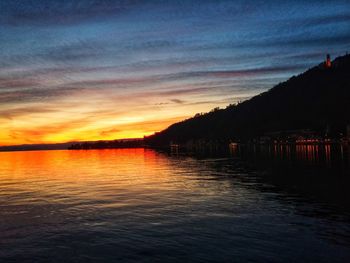 Scenic view of lake against sky at sunset