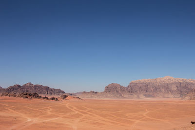 Scenic view of desert against clear blue sky