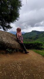 Woman standing on landscape against sky