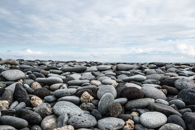 Pebbles on beach against sky