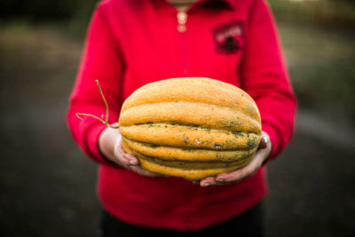 Midsection of man holding pumpkin