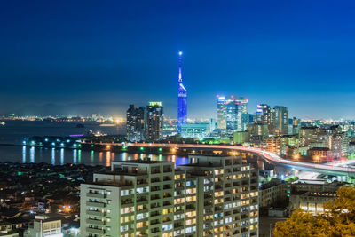 Illuminated buildings in city against sky at night