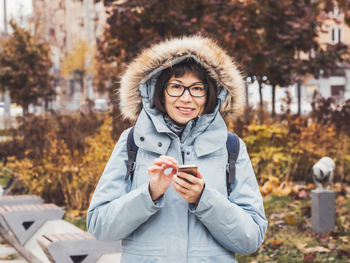 Smiling woman is texting someone on smartphone. online communication via wi-fi. wireless technology.