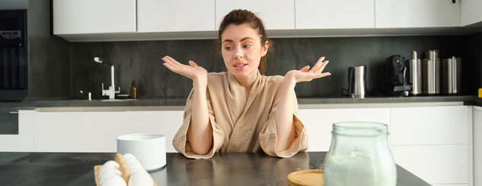 Portrait of young woman using mobile phone at home