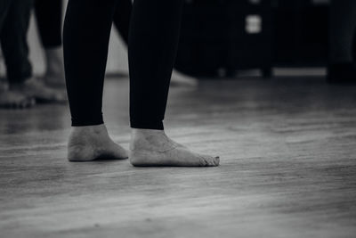 Low section of woman standing on hardwood floor