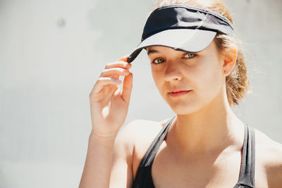 Portrait of young woman looking away against white background