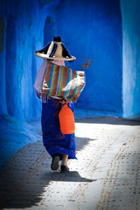 Full length rear view of man holding umbrella