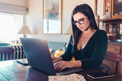 Young woman using mobile phone at home