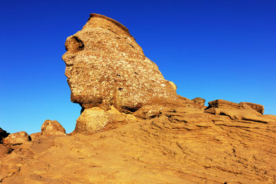 Sphinx of rock formations against clear blue sky