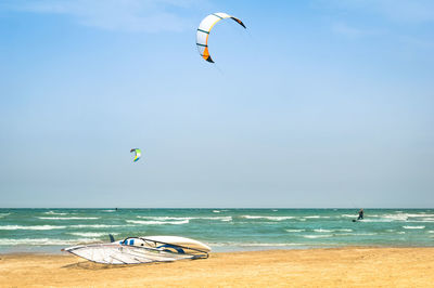 Kite on sea shore against sky