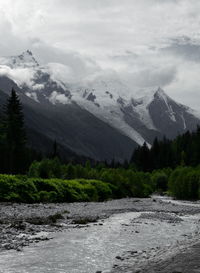 Scenic view of river and mountains against sky