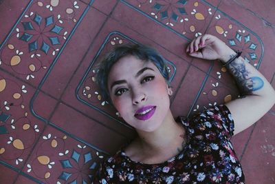 Portrait of beautiful woman lying on floor