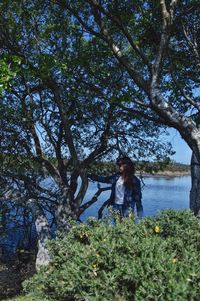 Woman standing by tree