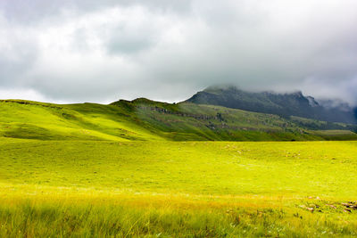 South africa drakensberge scenic panorama landscape, green plane and mountains in dense clouds 
