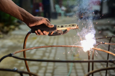 Midsection of man holding sparkler at night