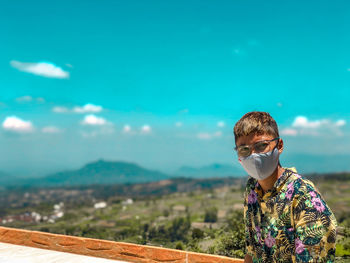 Portrait of man wearing sunglasses standing against sky