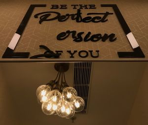 Low angle view of illuminated text hanging on wall at home
