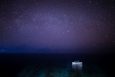 Scenic view of sea against star field at night