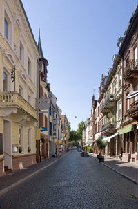 Street amidst buildings in town against sky